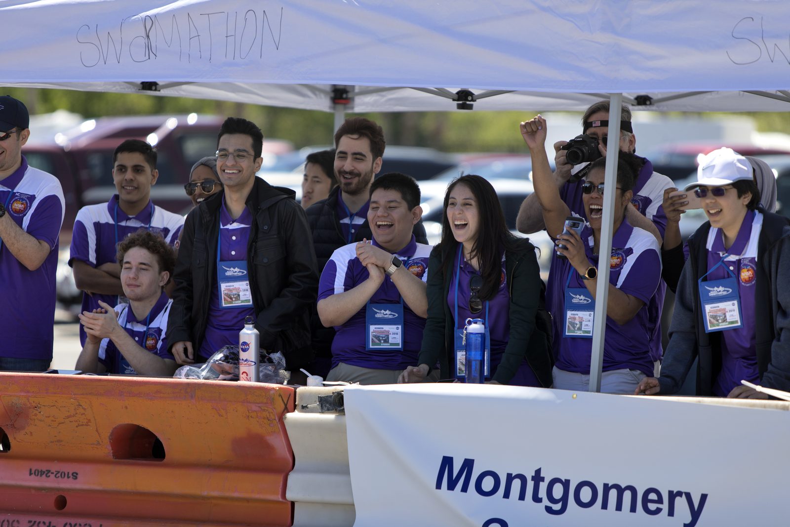 Someone working in Coding — Ellis Abel Learns Students from Montgomery College crouch beside their Swarmie robots, watching the code they wrote run during the Swarmathon competition. Real NASA photograph used on the Ellis Abel Learns "Why I Love Coding" page.