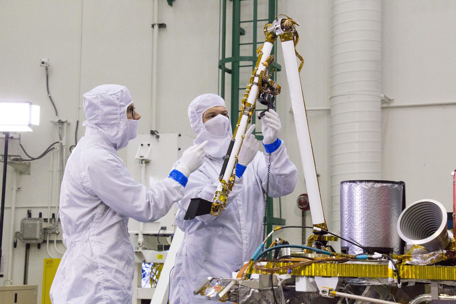 Someone working in Engineering — Ellis Abel Learns Engineers in clean-room suits test the robotic arm of the InSight Mars lander on a work stand before launch. Real NASA photograph used on the Ellis Abel Learns "Why I Love Engineering" page.