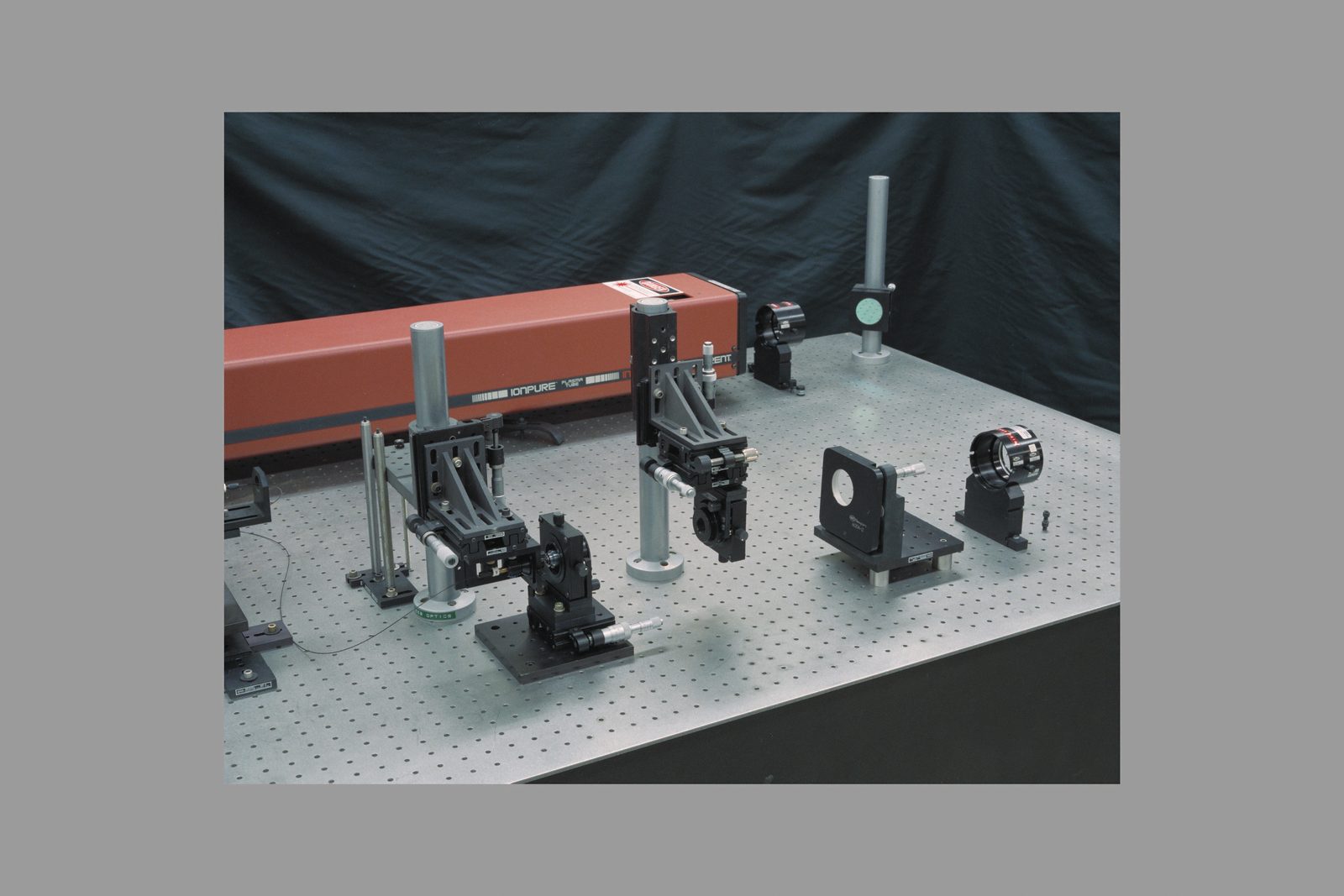 An optical bench in the Laser Optics Laboratory at Ames Research Center, crowded with mirrors, lenses and beam paths. Real NASA photograph used on the Ellis Abel Learns "Why I Love Lasers" page.