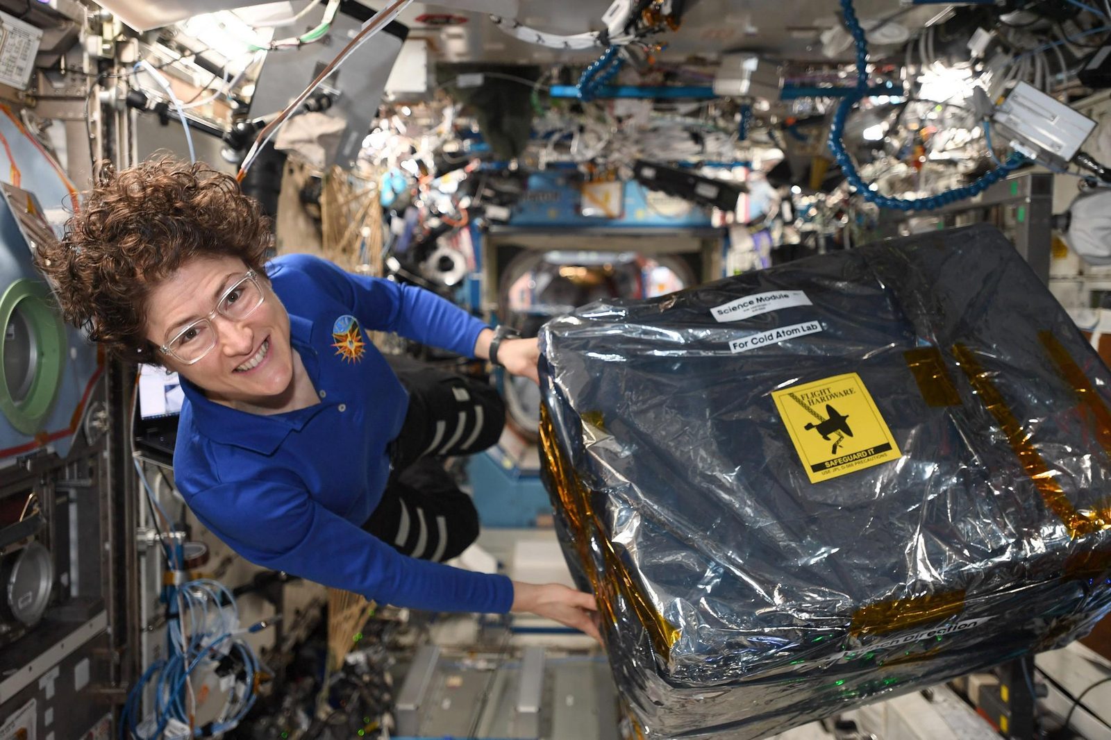 Someone working in Physics — Ellis Abel Learns Astronaut Christina Koch floats in the space station while unloading new hardware for the Cold Atom Lab experiment. Real NASA photograph used on the Ellis Abel Learns "Why I Love Physics" page.