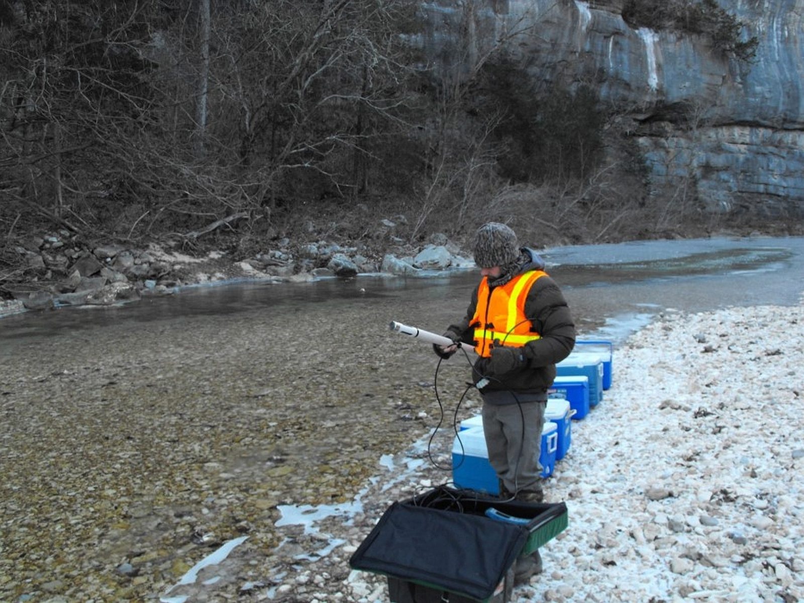 Someone working in Rivers — Ellis Abel Learns A USGS scientist stands in North Sylamore Creek in Arkansas filling sample bottles and measuring the stream water on site. Real USGS photograph used on the Ellis Abel Learns "Why I Love Rivers" page.