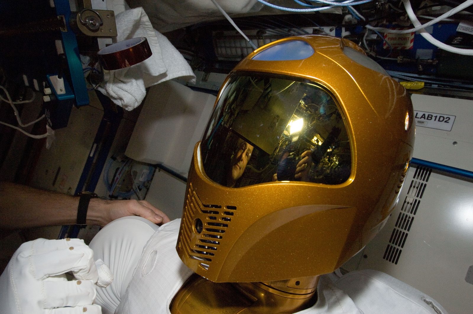 The Robonaut 2 humanoid robot, with a gold-visored head and two jointed arms, mounted inside the Destiny laboratory of the space station. Real NASA photograph used on the Ellis Abel Learns "Why I Love Robotics" page.