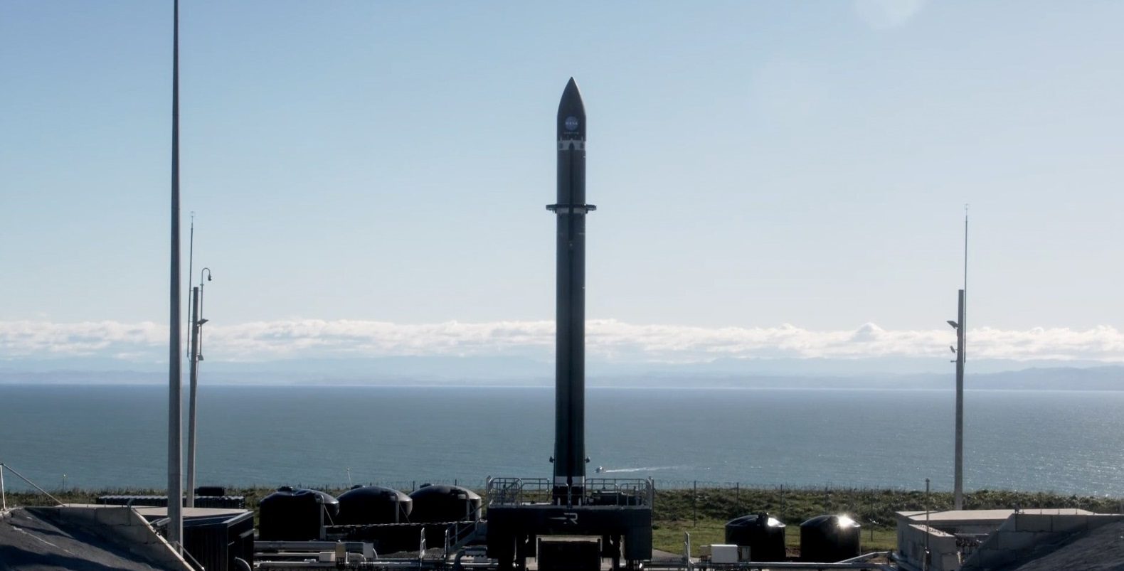 A Rocket Lab Electron rocket lifts off from its launch pad, trailing a bright orange exhaust plume. Real NASA photograph used on the Ellis Abel Learns "Why I Love Rockets" page.