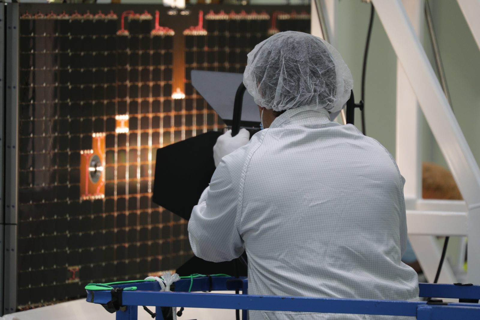 Someone working in Solar Power — Ellis Abel Learns A technician holds a light rig against an Orion solar array wing panel during an illumination test. Real NASA photograph used on the Ellis Abel Learns "Why I Love Solar Power" page.